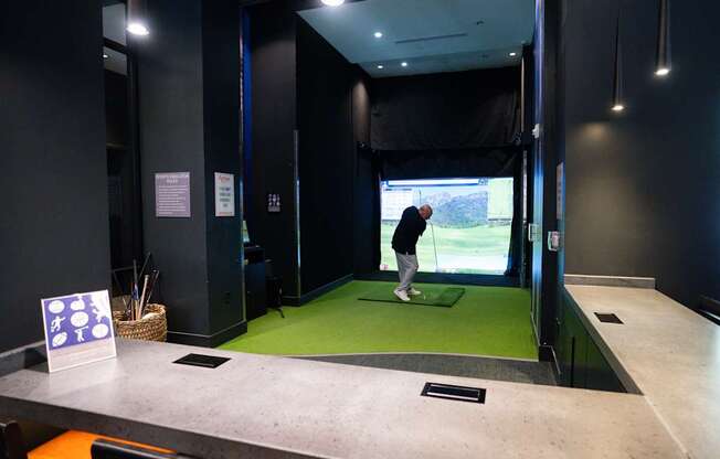 Man playing on a golf simulator at Arrive Federal Hill