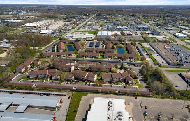 an aerial view of a city with cars parked in a parking lot