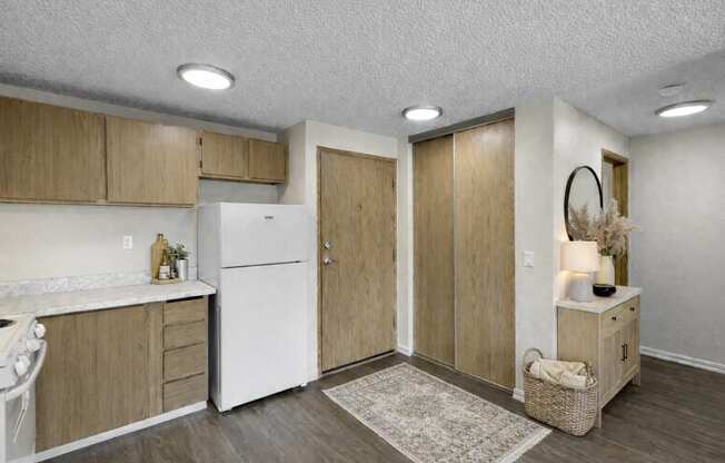 A kitchen with wooden cabinets and a white refrigerator.