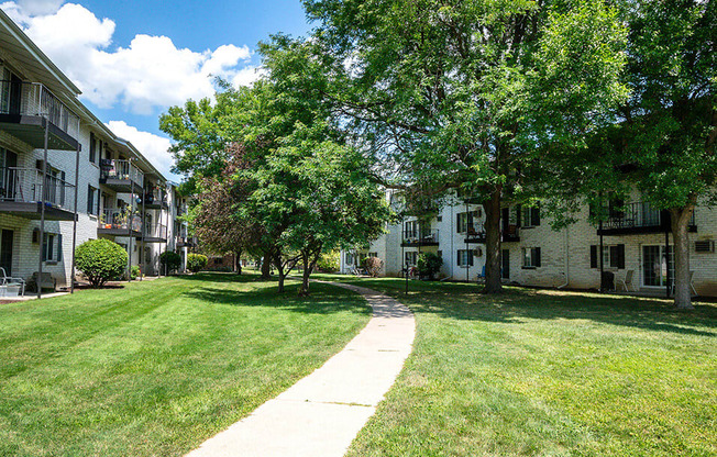 sidewalk with large shady trees at rivers edge apartments