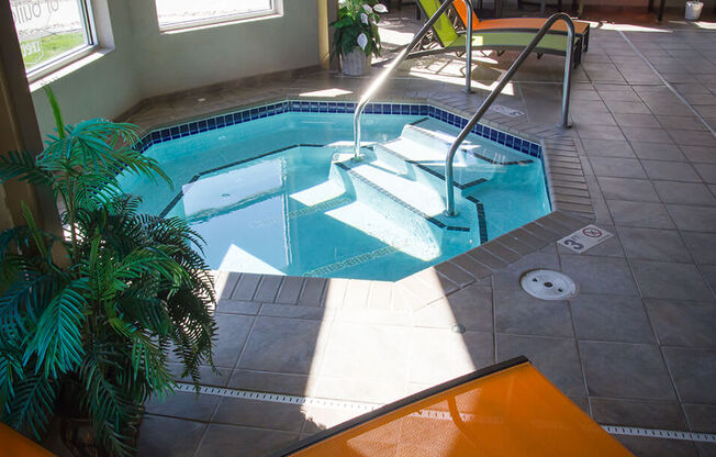 a plunge pool in a home with a tile floor and floor to ceiling windows