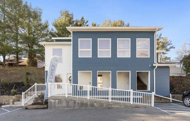 a blue house with a white fence in front of it