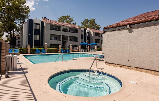 a swimming pool with a hot tub in front of an apartment building