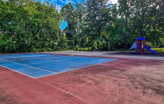 a tennis court with a blue court and a playground