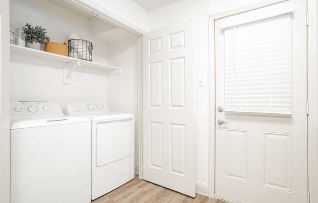 a laundry room with a washer and dryer and a white door