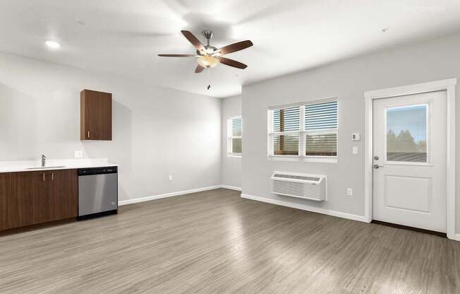 A spacious room with a ceiling fan and a dishwasher.