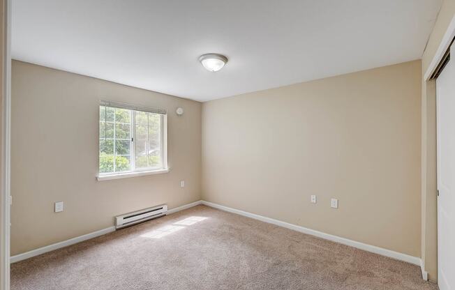 an empty room with a window and a door