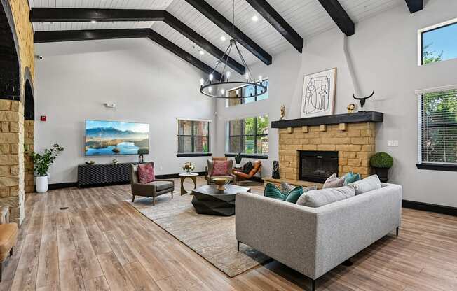 A living room with a grey couch and a fireplace.