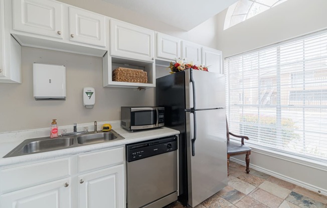 a kitchen with stainless steel appliances and a sink and refrigerator