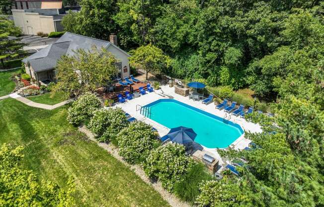an aerial view of a backyard with a pool and a house