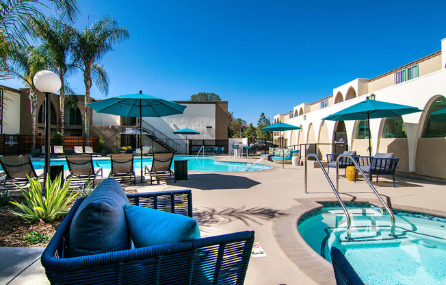 a patio with a pool and chairs and umbrellas  at Veranda La Mesa, California