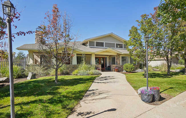 A house with a well-maintained lawn and a sidewalk in front.