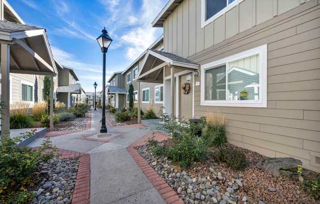 A street lamp stands in the middle of a pathway between houses.