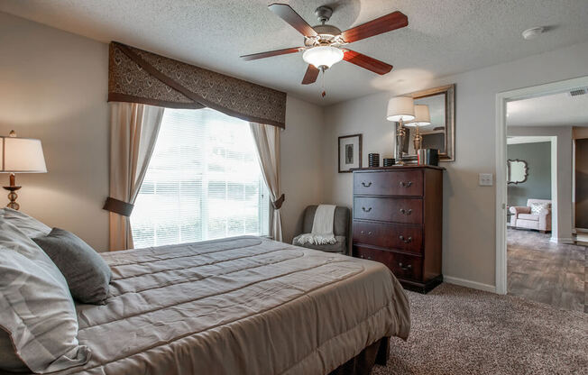 A bedroom with a bed, dresser, and mirror.