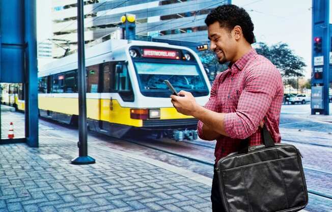 Man on cell phone near public transportation train
