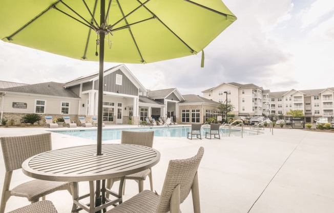 our apartments have a large pool and patio with chairs and tables