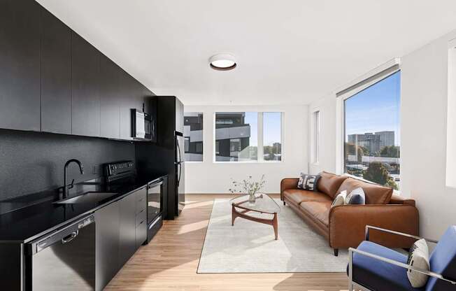 A modern kitchen with black cabinets and stainless steel appliances.