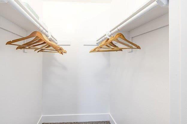 Two wooden hangers are hanging on a white wall.