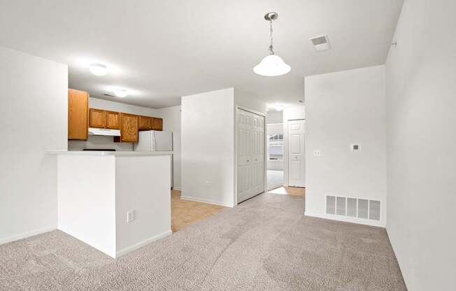 A white kitchen with a white island and a white fridge.