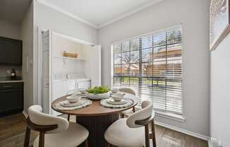A dining room with a round table and chairs.