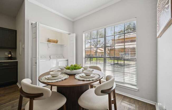 A dining room with a round table and chairs.