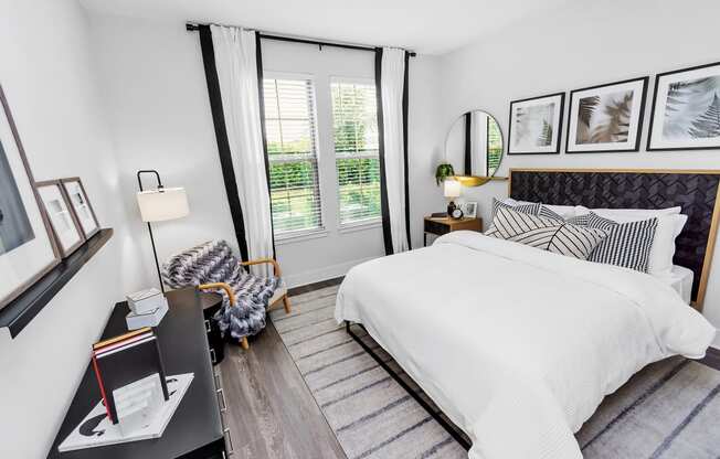 a bedroom with white bedding and black and white decor