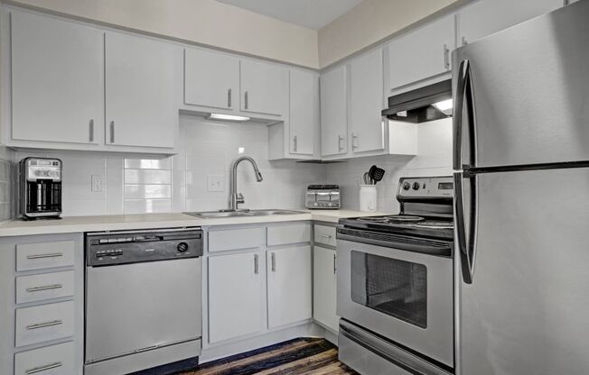 a kitchen with stainless steel appliances and white cabinets at Latitude 2976, Texas, 77042