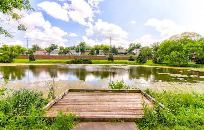 a wooden dock is in the middle of a pond