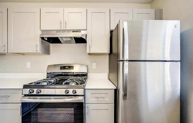 A modern kitchen with a stainless steel refrigerator, oven, and range at Sterling Point Apartment Homes, Phoenix, Arizona