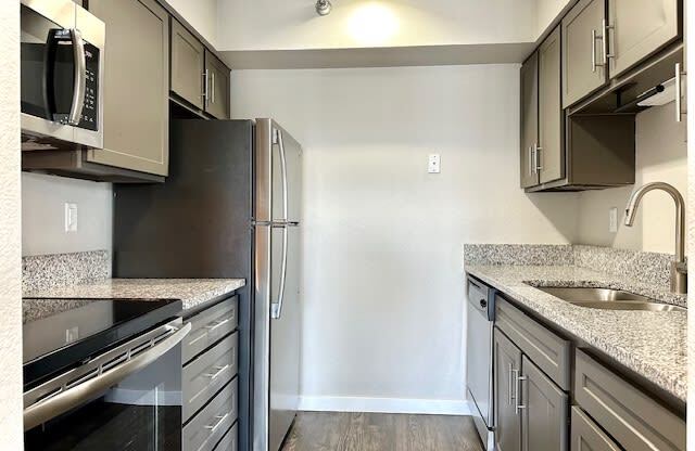 a kitchen with granite counter tops and stainless steel appliances