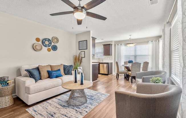 A living room with a white couch, a coffee table, and a ceiling fan.