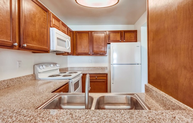 a kitchen with wooden cabinets and granite countertops