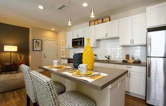 Modern kitchen with ample storage in the white cabinetry. The kitchen island is spacious and perfect for entertaining guests.