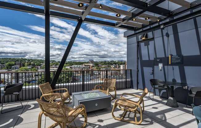 A patio with a table and chairs overlooking a cityscape.