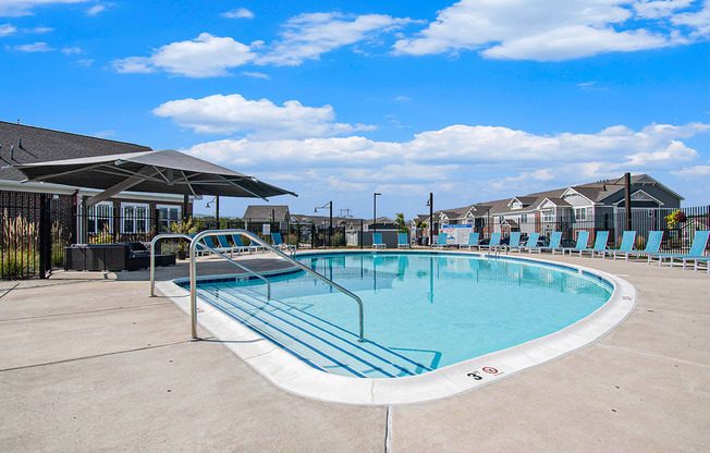 A large outdoor swimming pool with lounge chairs at Strathmore Apartment Homes, West Des Moines, IA
