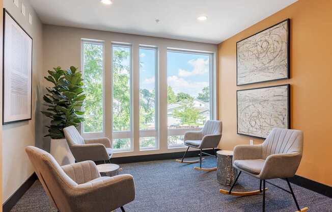 A room with orange walls and a large window with a view of trees and a blue sky.
