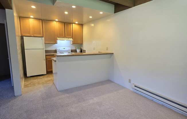 the living room and kitchen of an empty house with a carpeted floor