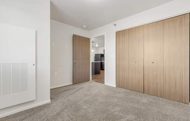 A room with a carpeted floor and wooden doors.