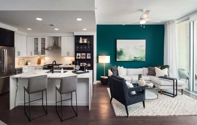 a living room and kitchen with a green accent wall