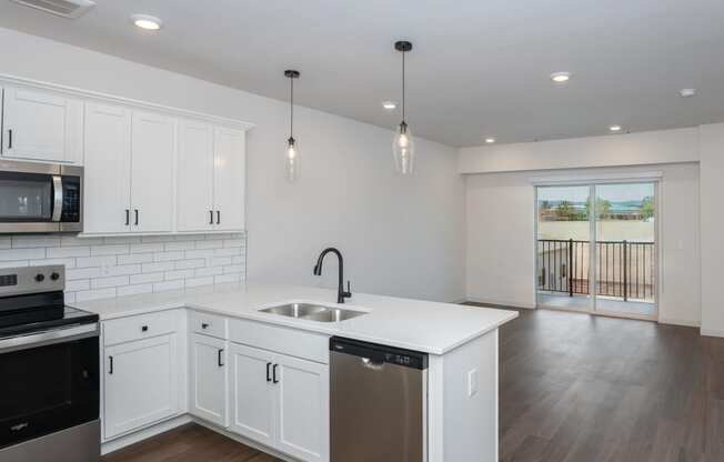 a renovated kitchen with white cabinets and a white counter top and a stainless steel sink at The Crossings at Windsong, Prescott Valley, 86314
