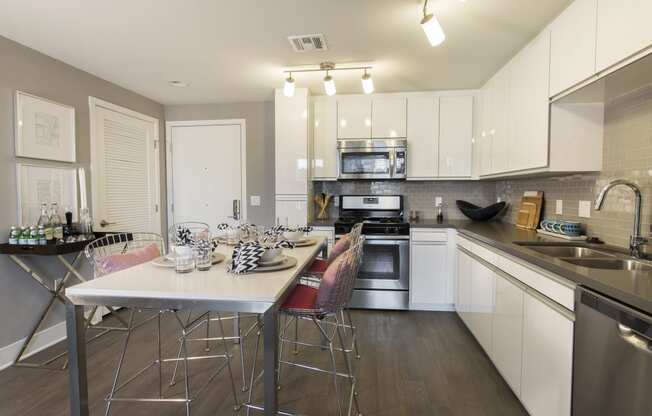 a kitchen with white cabinetry and stainless steel appliances