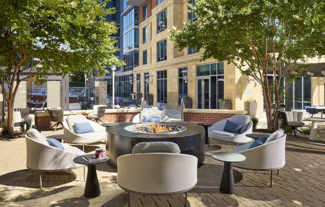 a patio with chairs and tables and a fire pit