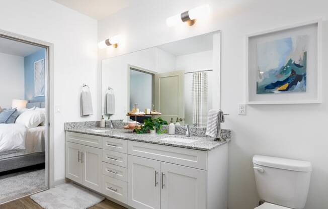 a white bathroom with a large mirror and a toilet