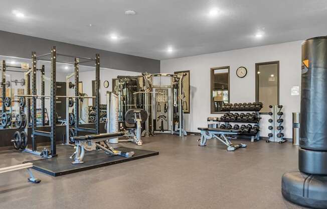A gym with a variety of equipment including weights and weight machines.