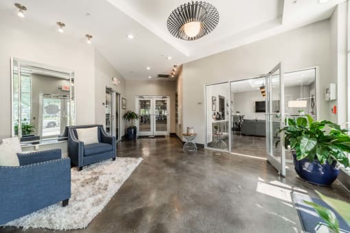 a living room with a couch and a chair in front of a mirror