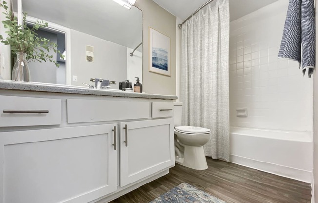 A white bathroom with a toilet, sink, and bathtub.