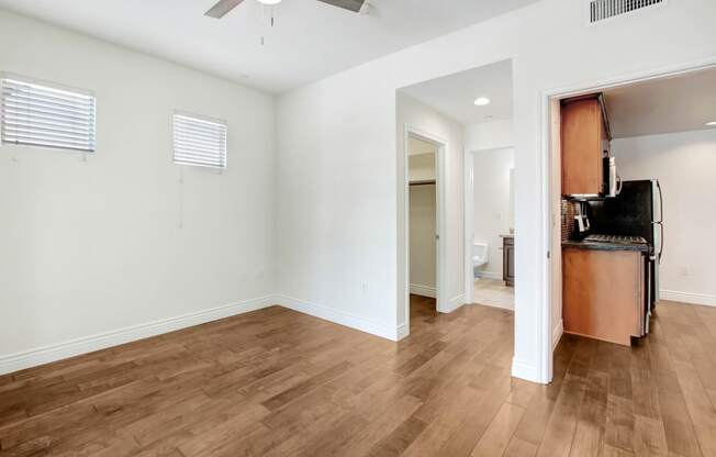 a living room with a kitchen and a hard wood floor