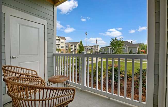 Balcony with two patio chairs and a table. Storage space on balcony at Ascent at Mallard Creek Charlotte, NC