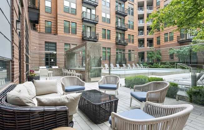 a patio with chairs and a table in front of a building