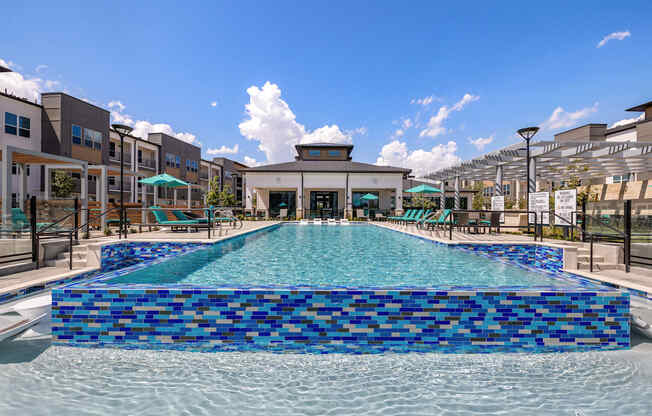 A large blue tiled pool in the middle of a building complex.